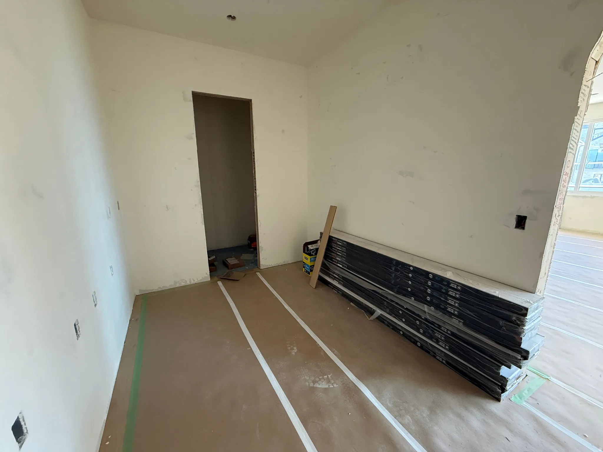 Unfinished interior space featuring light-toned walls and an open doorway
