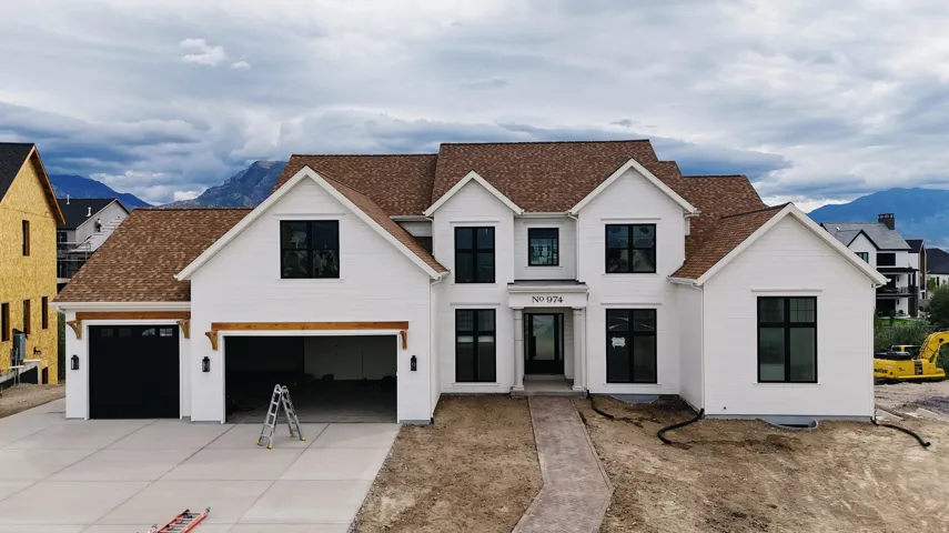 Modern farmhouse architecture with white siding and a brown shingle roof