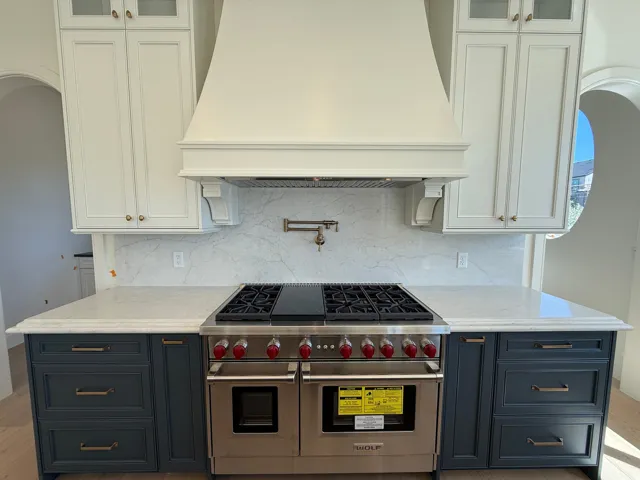 Professional-grade stainless steel range with a pot filler, set against a stone slab backsplash