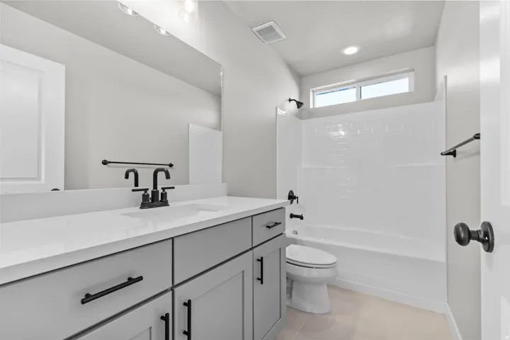 Contemporary bathroom featuring a light gray vanity with a white countertop and a rectangular undermount sink