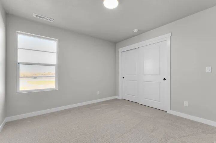 Neutral wall paint with coordinating light carpet flooring, white trim, and a window with a white frame