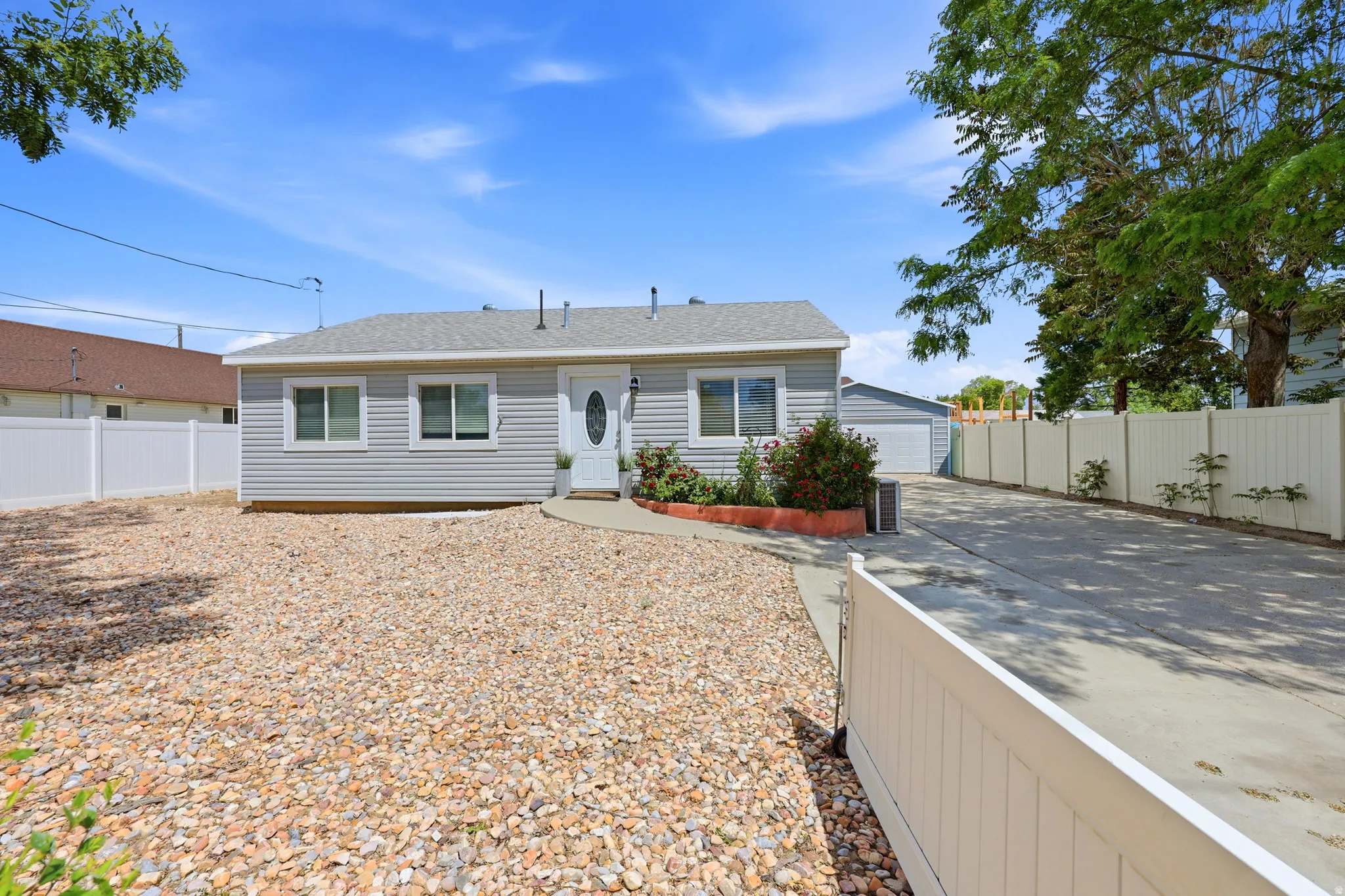 Light gray siding exterior with a white front door and decorative glass insert