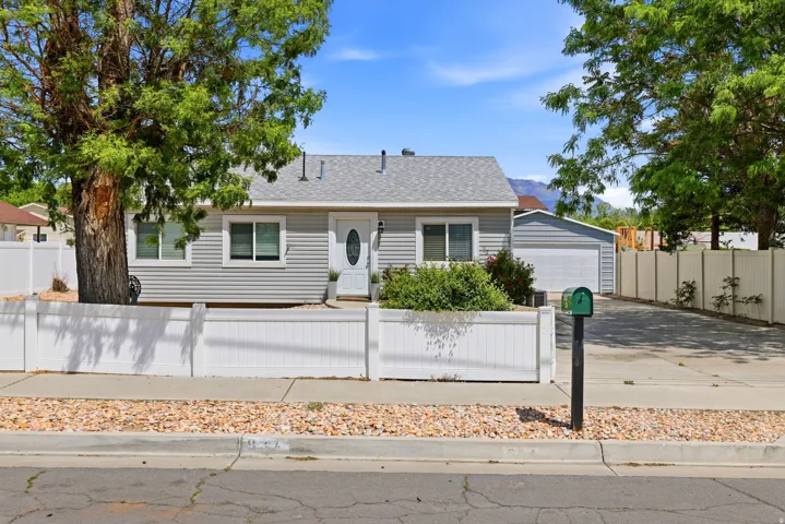 Ranch-style exterior featuring light gray siding, a white front door with an oval glass insert, and a gray shingle roof