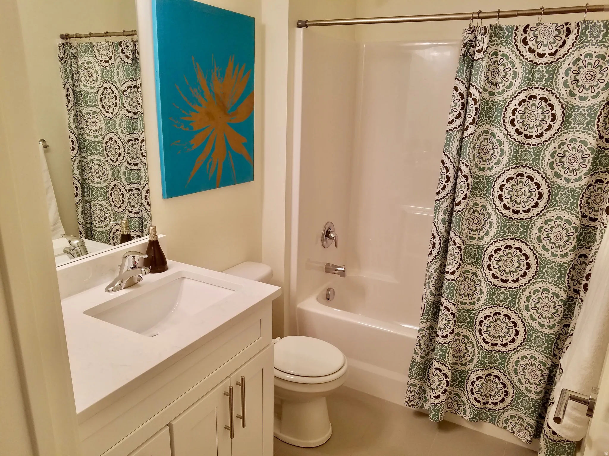 Bathroom featuring a white vanity with an integrated sink, polished chrome faucet, and a large wall-mounted mirror