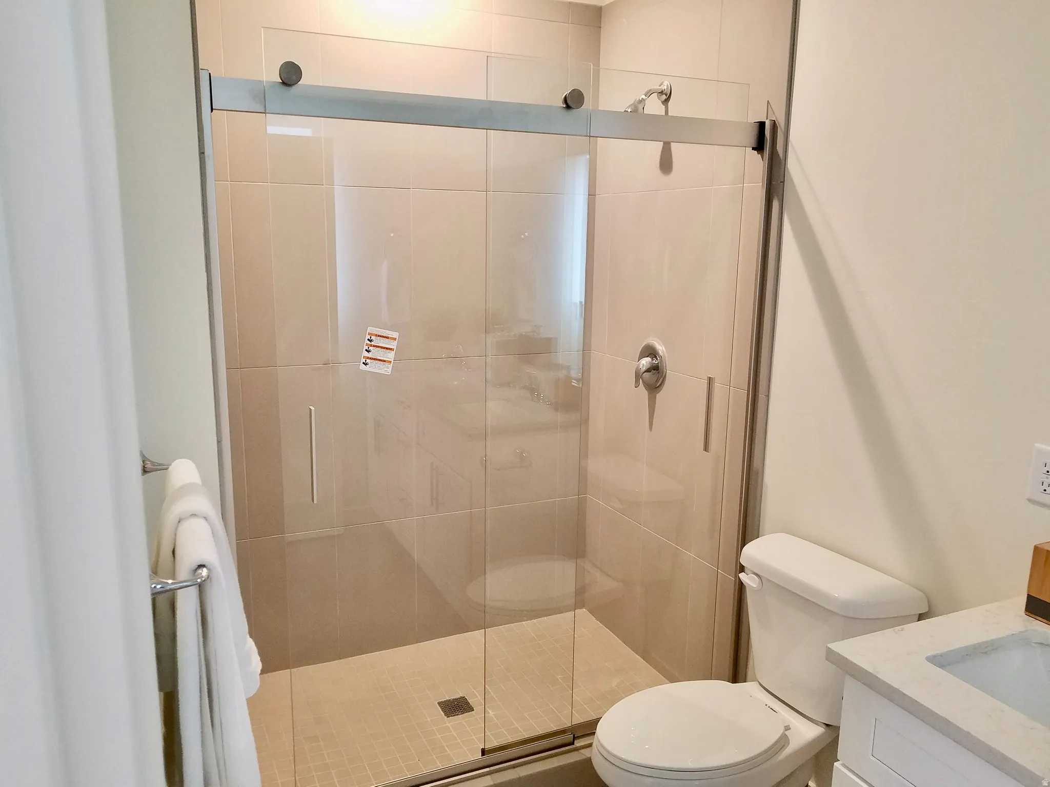 Enclosed shower with sliding glass doors, large format tile surround. Picture was taken at time of building.