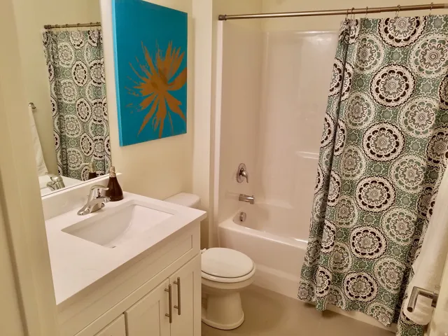 Bathroom featuring a white vanity with an integrated sink, polished chrome faucet, and a large wall-mounted mirror