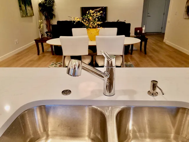 Kitchen sink featuring a dual basin, chrome pull-down faucet, and white countertop