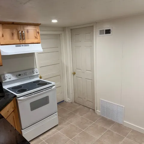 Kitchen area featuring tile flooring and a white electric range