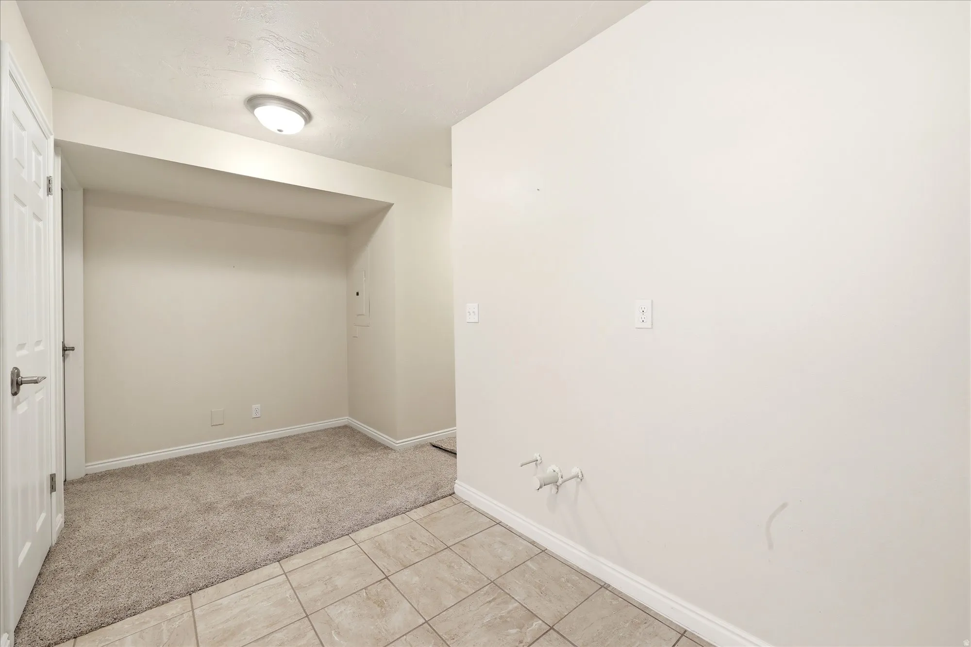 Utility space featuring an overhead light fixture, light gray wall paint, and white baseboards