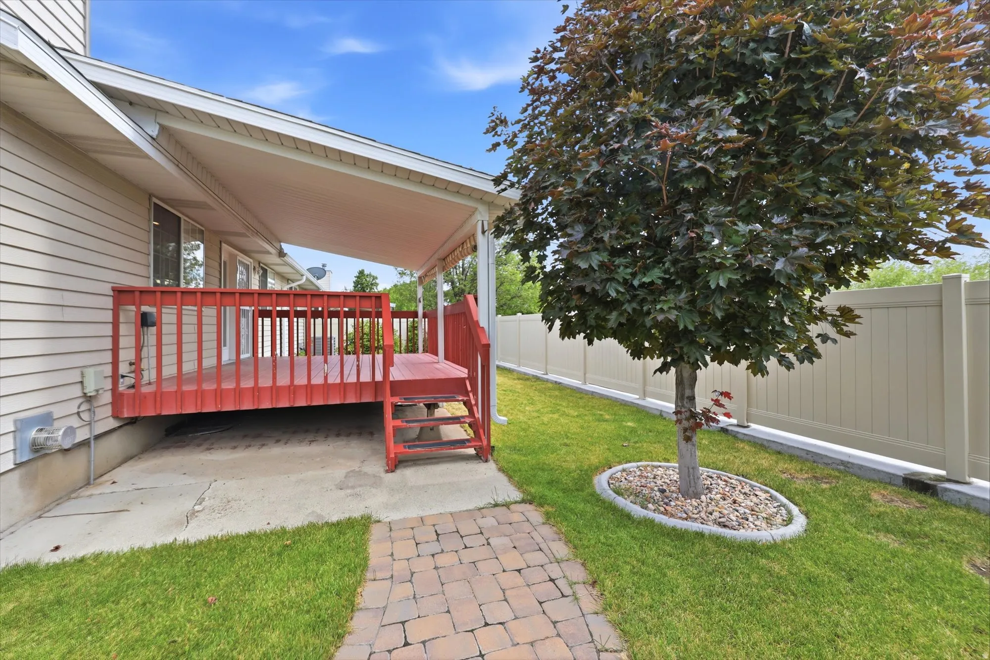 Covered wood deck with red railings, offering outdoor living space