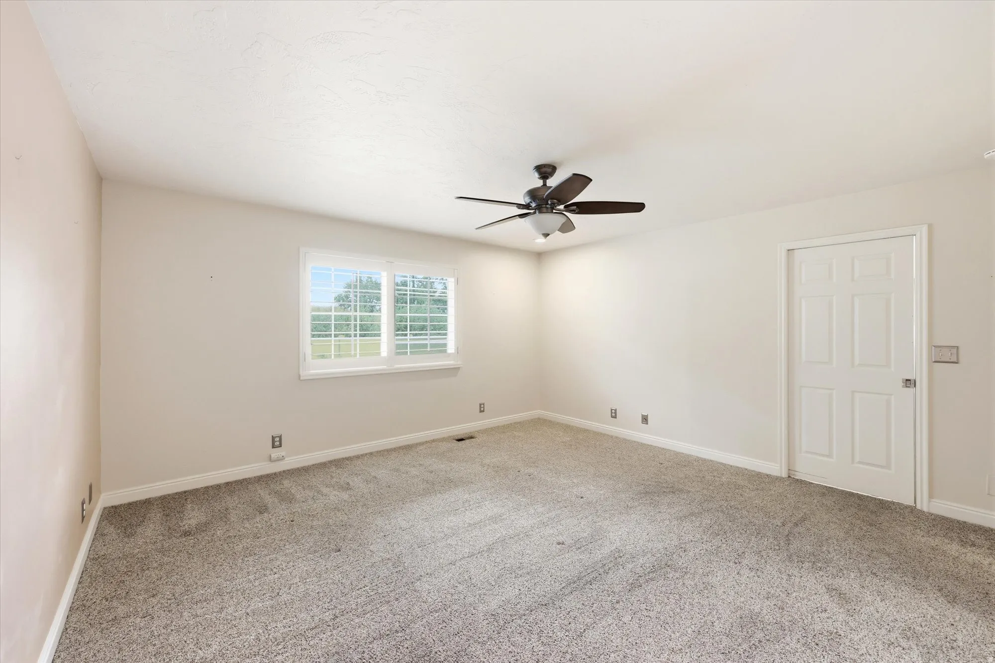 Spacious room featuring neutral carpeting and light-toned walls