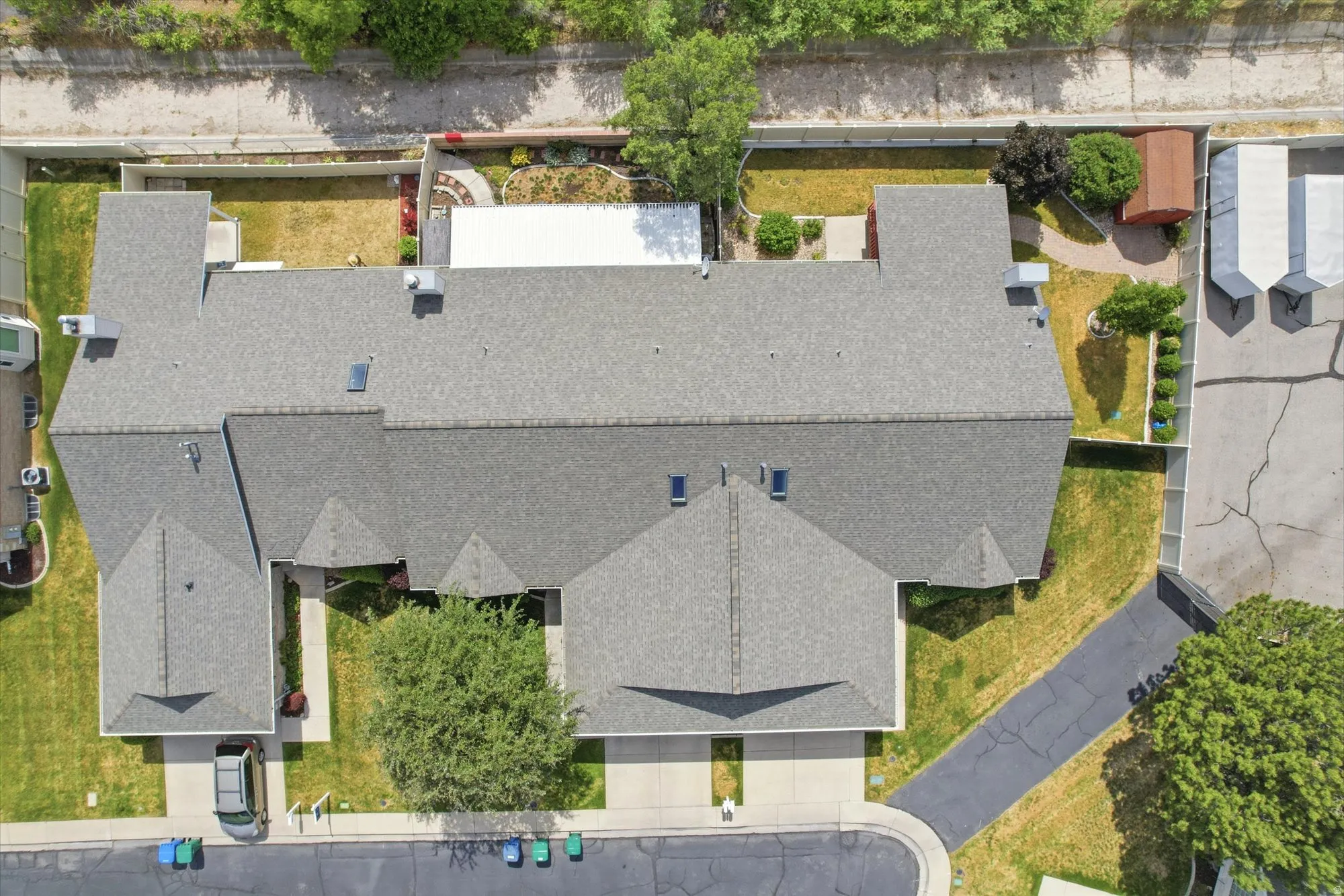Aerial perspective showcasing a multi-unit property with gray shingle roofing