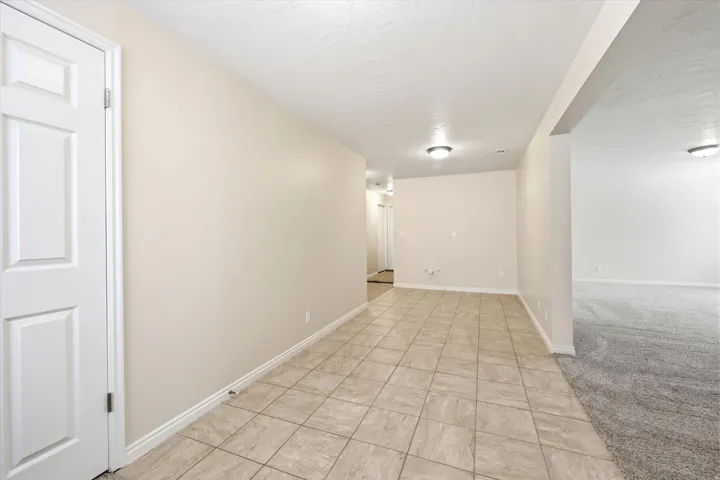 Tiled entry area featuring warm neutral wall tones and white baseboards