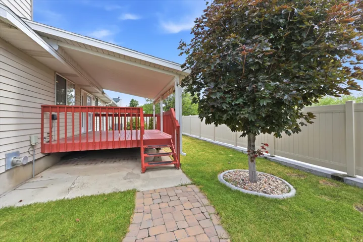 Covered wood deck with red railings, offering outdoor living space