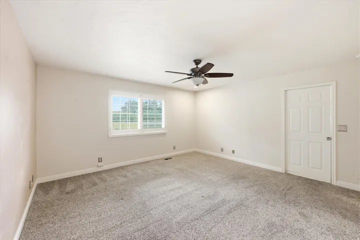 Spacious room featuring neutral carpeting and light-toned walls