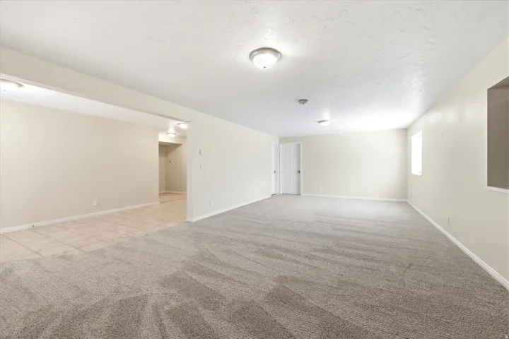 Expansive room featuring plush grey carpeting and neutral wall tones