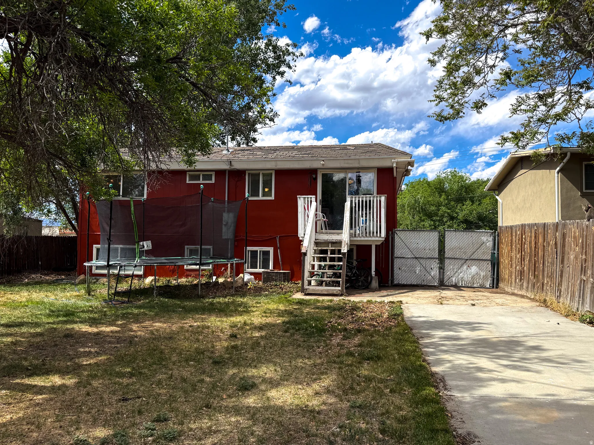 Red exterior with white trim windows and a white-railed deck with stairs
