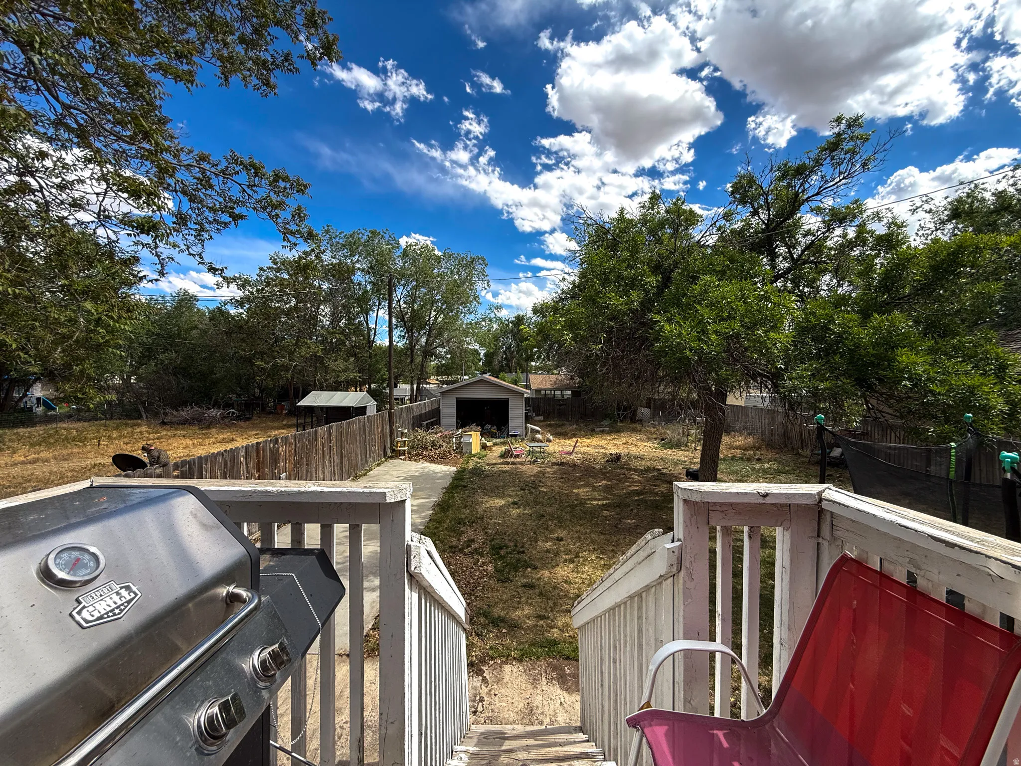 Expansive backyard with a wooden fence and mature trees