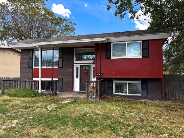 Split-level residence featuring a brown brick lower facade and red siding