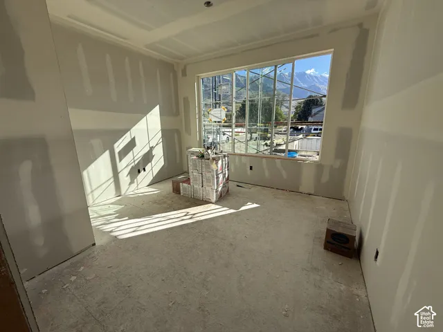 Interior space featuring unfinished drywall and a large multi-pane window