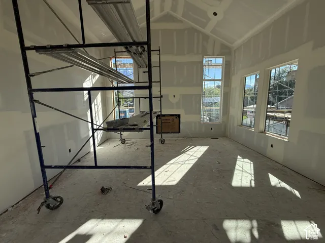 Vaulted ceiling, multiple windows, and a built-in fireplace opening