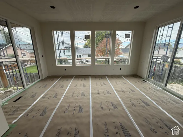 Sun-drenched interior featuring floor-to-ceiling windows, dual glass sliding doors, and recessed lighting