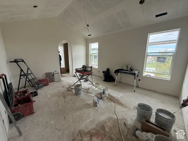 Primary Bedroom with Vaulted ceilings featuring recessed lighting fixtures and a prominent arched entryway