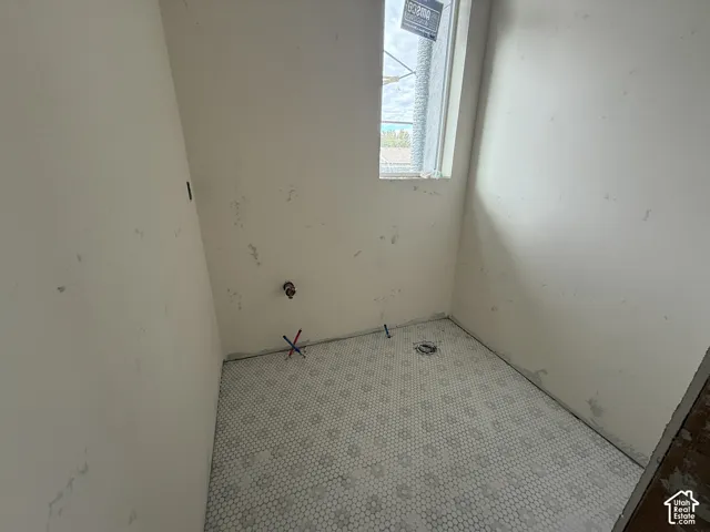 Room featuring white hexagonal floor tile and a vertical window