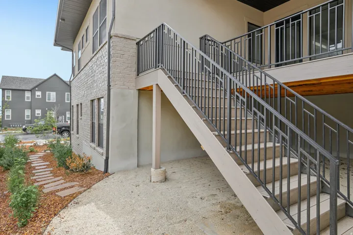 Exterior staircase with geometric metal railings, providing access to an upper-level entry