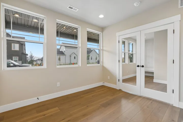 Bright room featuring three large windows and wood-finish flooring