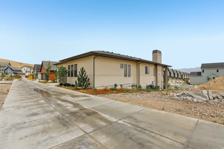 Contemporary exterior with a light stucco finish, dark trim, and a prominent chimney feature