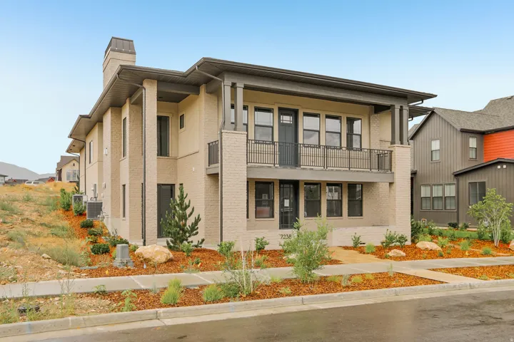 Modern multi-story property featuring light brick and horizontal siding