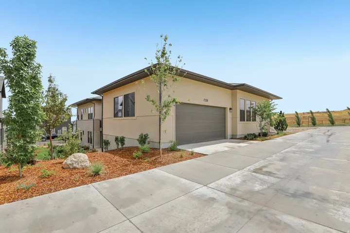 Contemporary stucco exterior featuring a dark gray garage door and contrasting trim