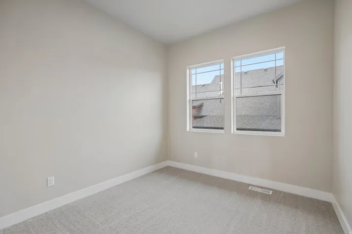 Bright interior space featuring dual windows with grid patterns