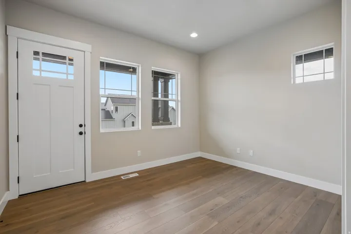 Open room featuring wood-finish flooring and light-toned walls