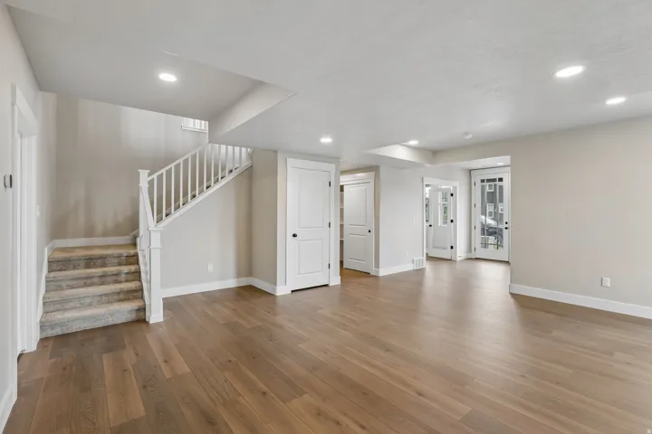 Expansive room with wood-finish flooring, recessed lighting, and neutral wall tones