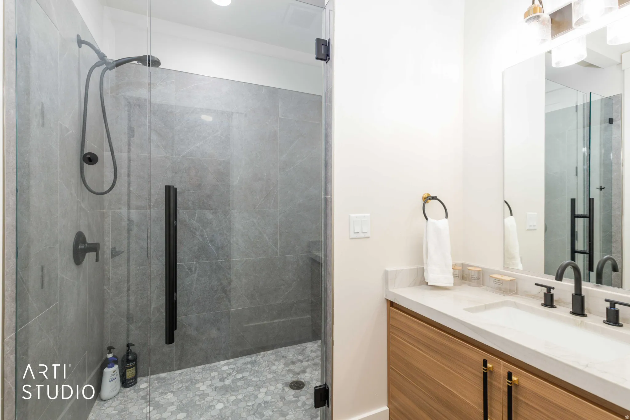 Contemporary bathroom featuring a spacious glass-enclosed shower with large format wall tiling and hexagonal floor tiling
