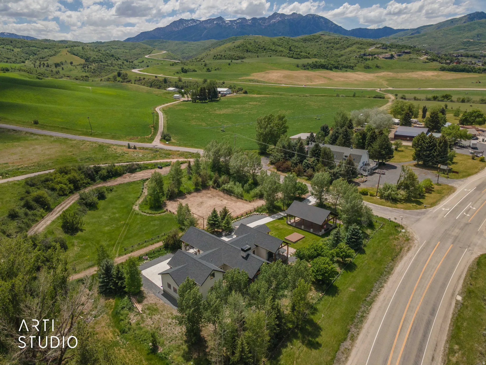 Expansive property with multiple buildings, mature trees, and a paved driveway