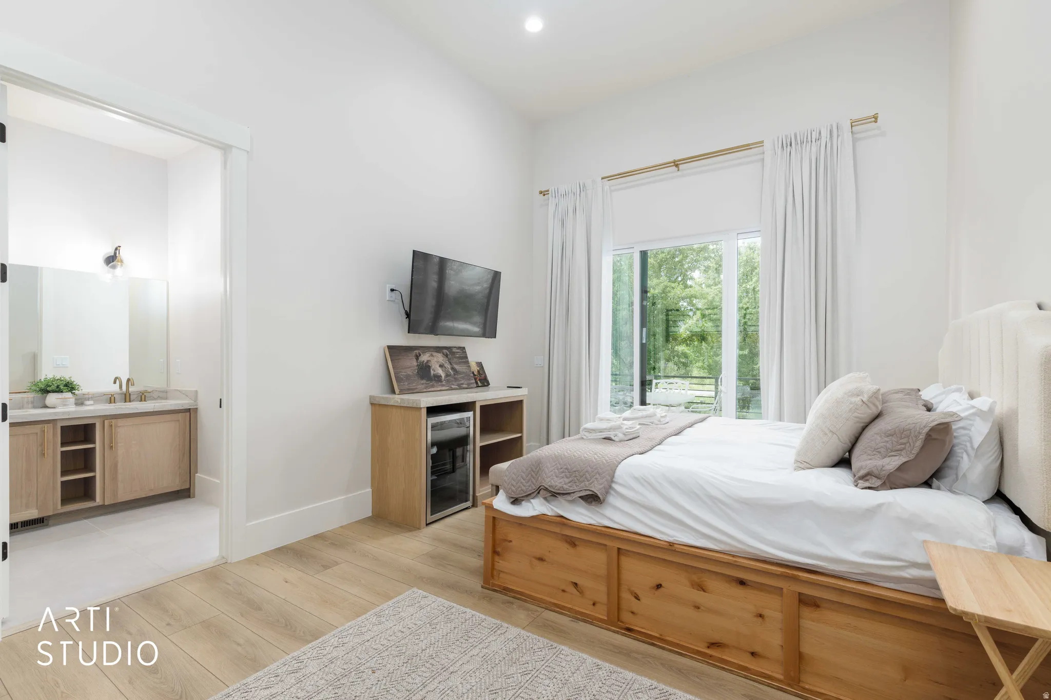 Spacious room with wood-finish flooring, a large sliding glass door, high ceilings, and a built-in beverage refrigerator