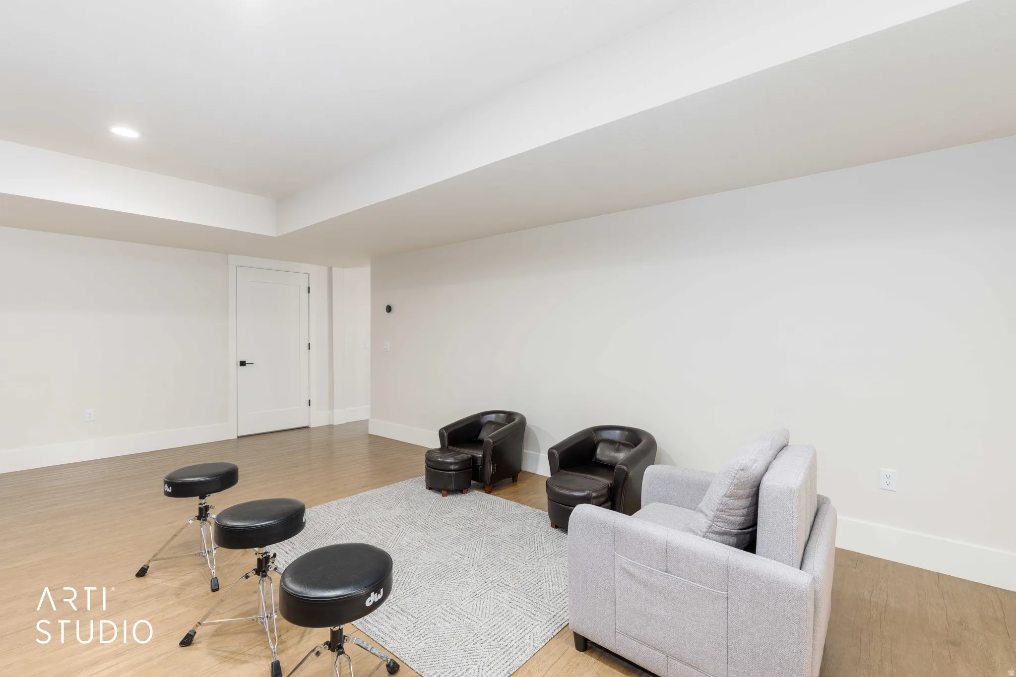 Spacious room featuring light wood-finish flooring, recessed lighting, white walls, and bright white trim