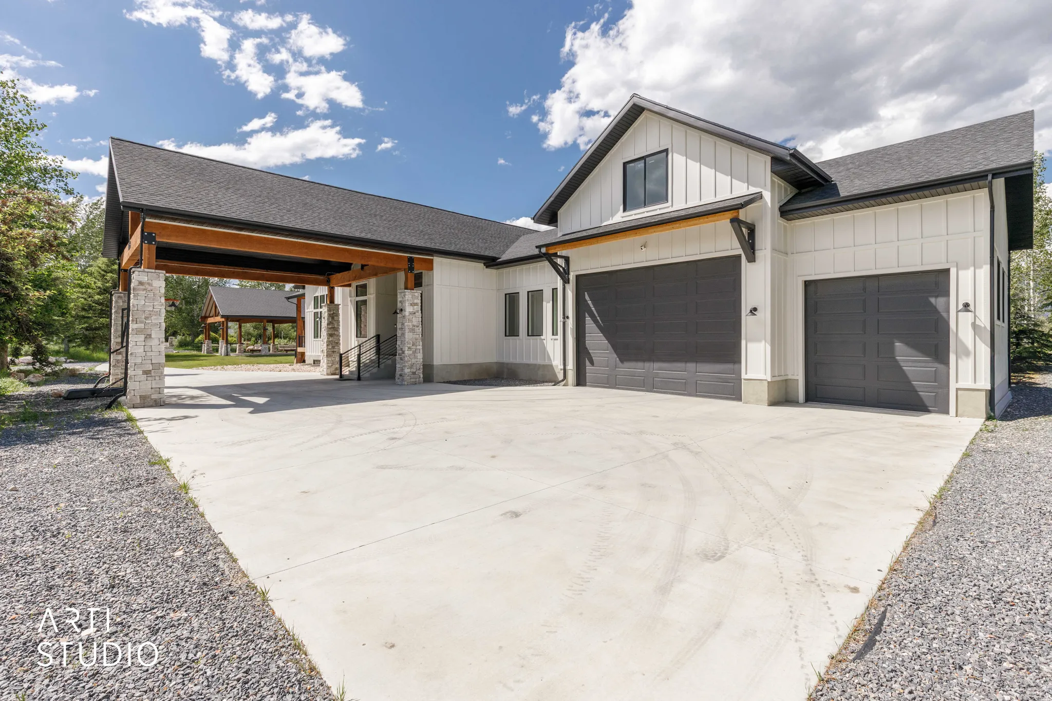 Modern farmhouse exterior featuring board and batten siding, dark-framed windows, and a black shingled roof