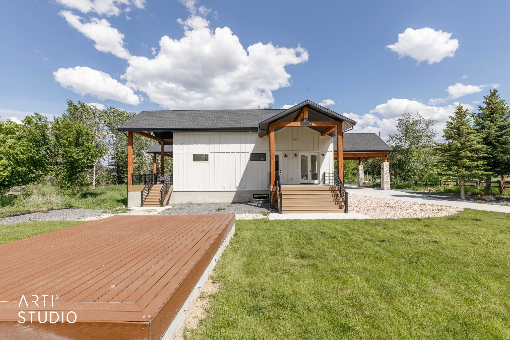 Modern farmhouse exterior with white vertical siding and dark-trimmed windows
