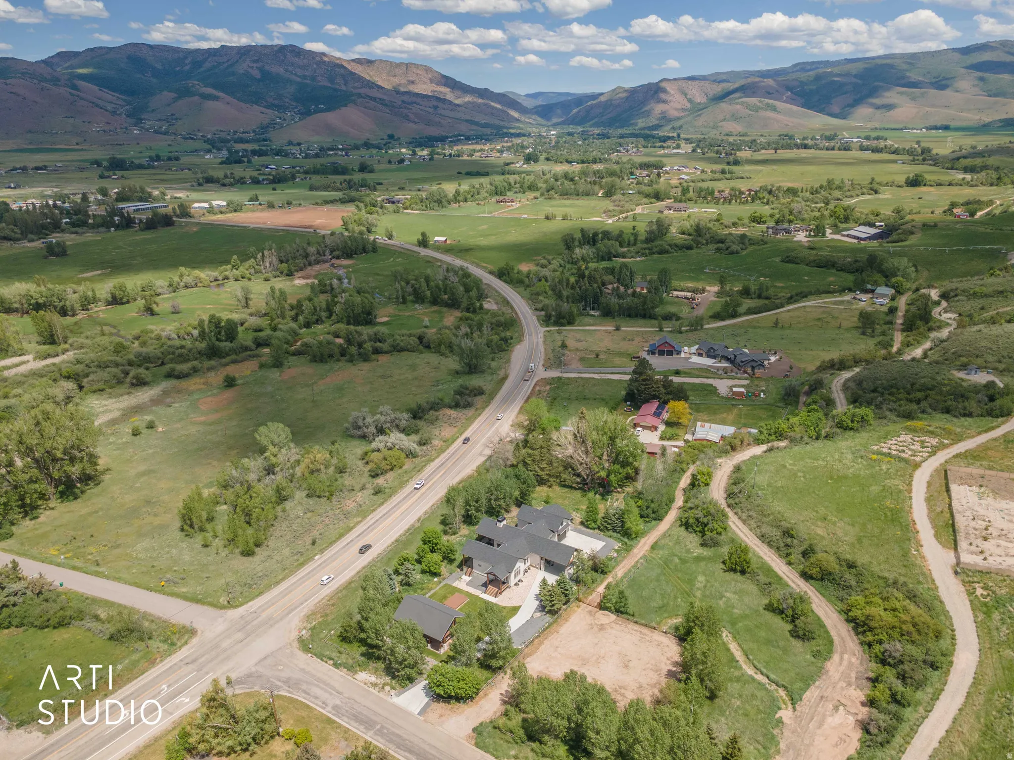 Expansive rural landscape featuring distant mountains and valleys, with scattered residential properties