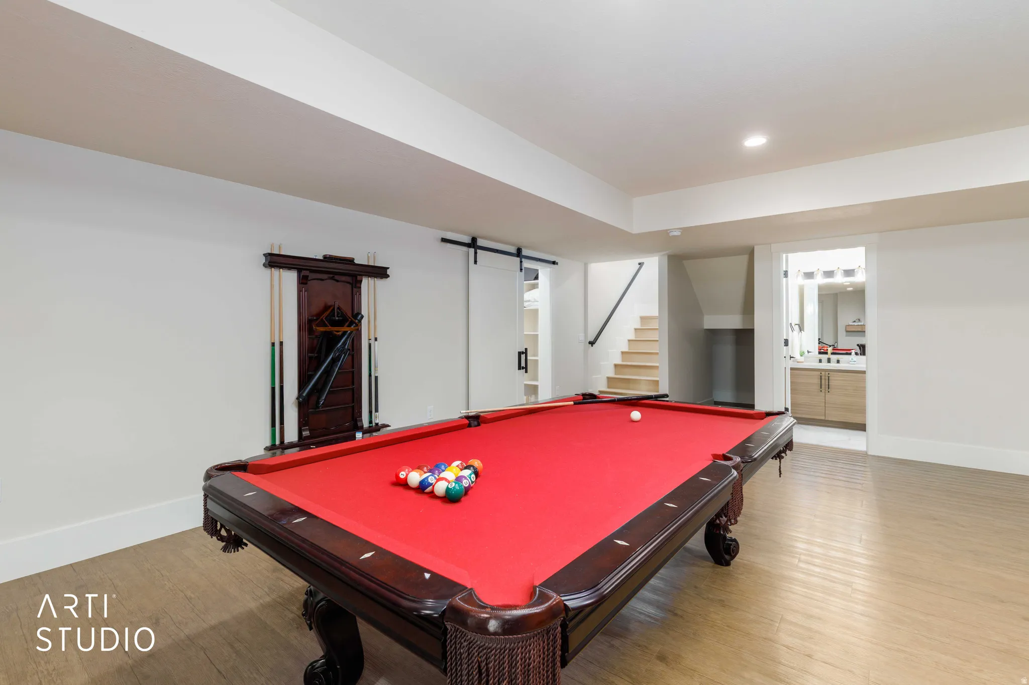 Recreation room featuring wood-finish flooring, recessed lighting, and a built-in cue rack