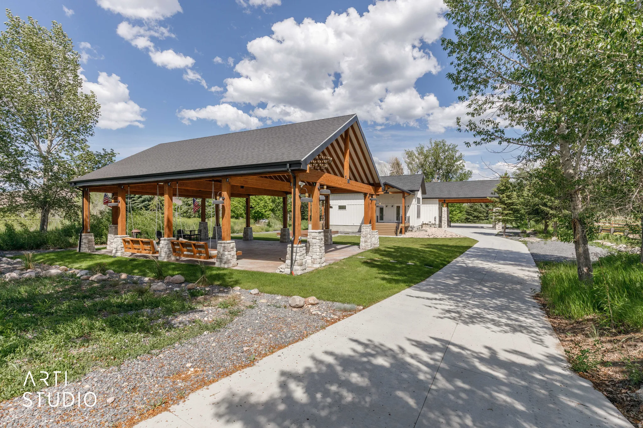 Expansive outdoor pavilion featuring exposed timber framing and stone-clad pillars