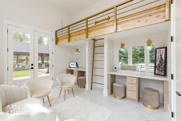 Interior space with a wood-finish loft featuring a gold-toned railing and ladder, dual vanity stations with integrated mirrors and wall sconces, and white tile flooring
