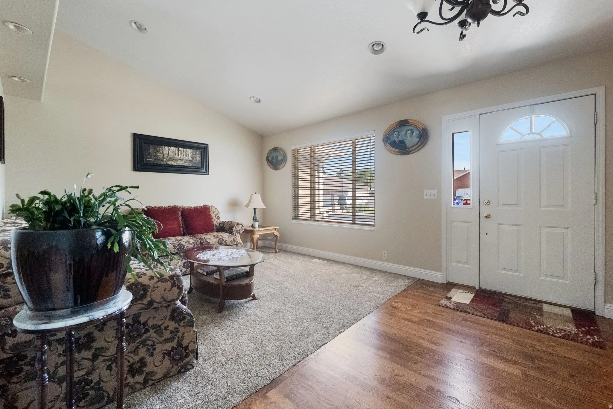 Entryway and living area featuring wood-refinished hardwood flooring and new carpet.