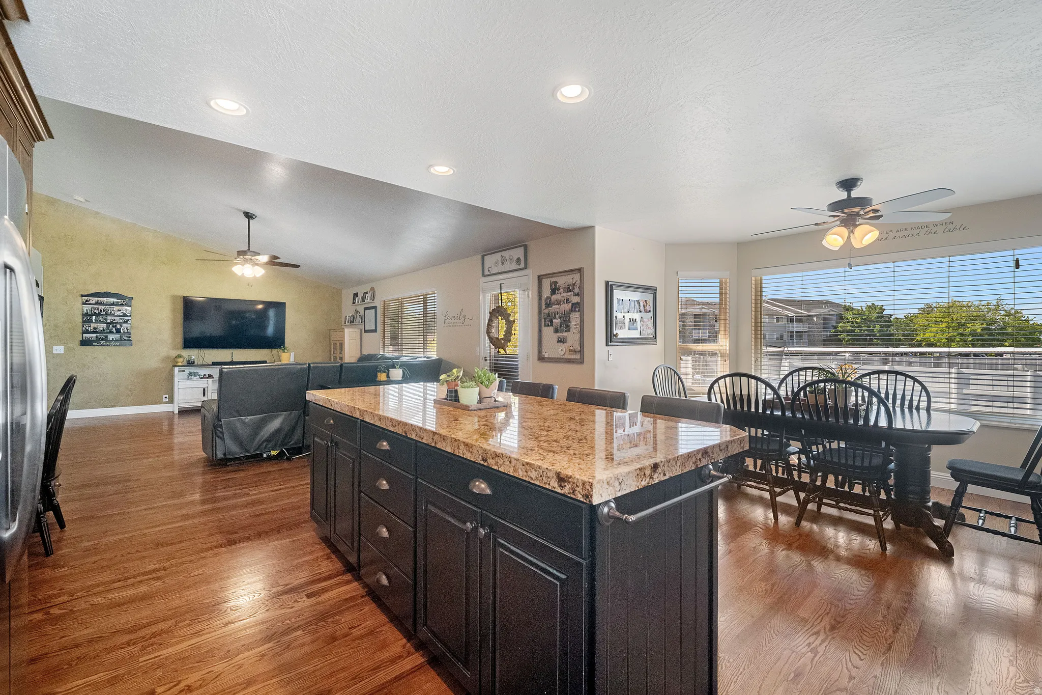 Open-concept kitchen and living area featuring refinished hardwood flooring, and large dining area.