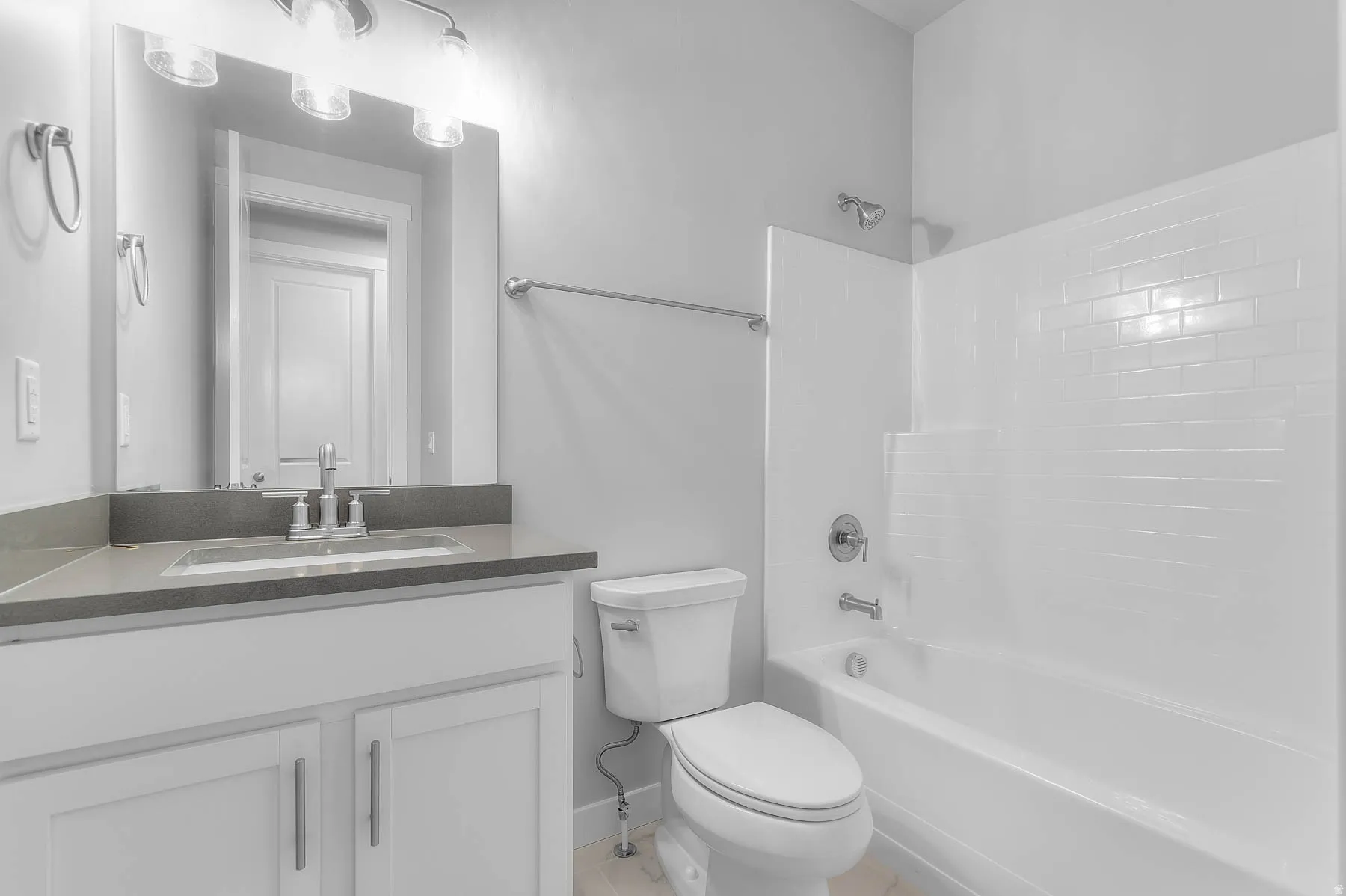 Bathroom featuring a white vanity with a gray countertop, an integrated sink, and a chrome faucet