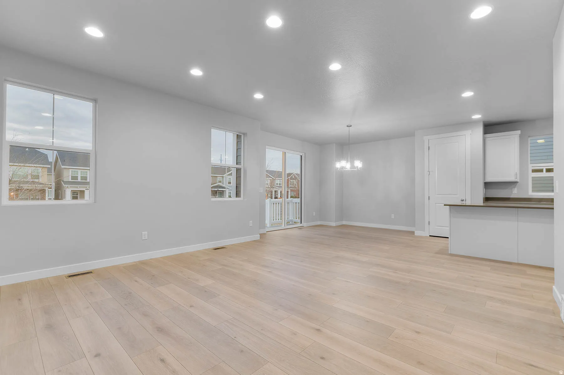Bright open-concept living space featuring light wood-finish flooring and recessed lighting